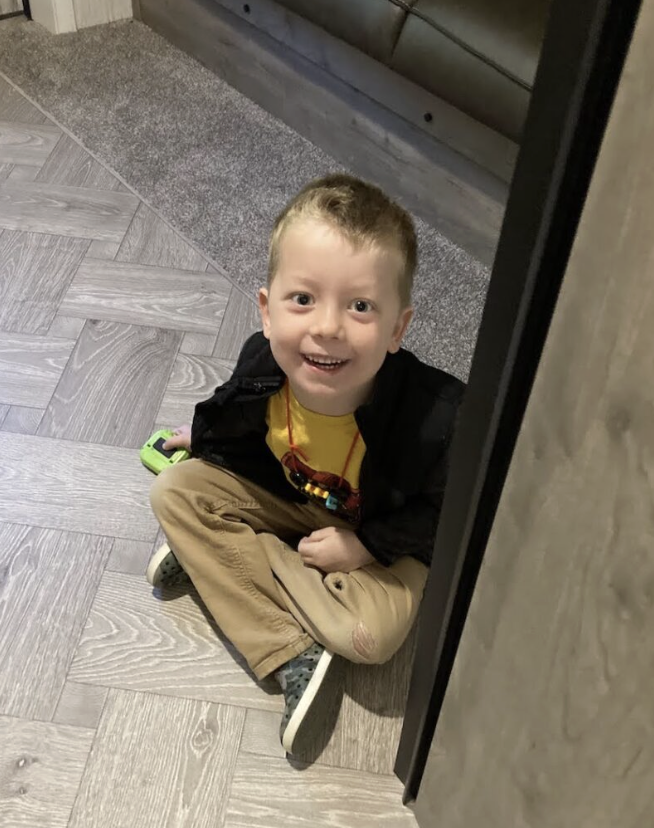 A little boy sitting on the floor in a camp trailer