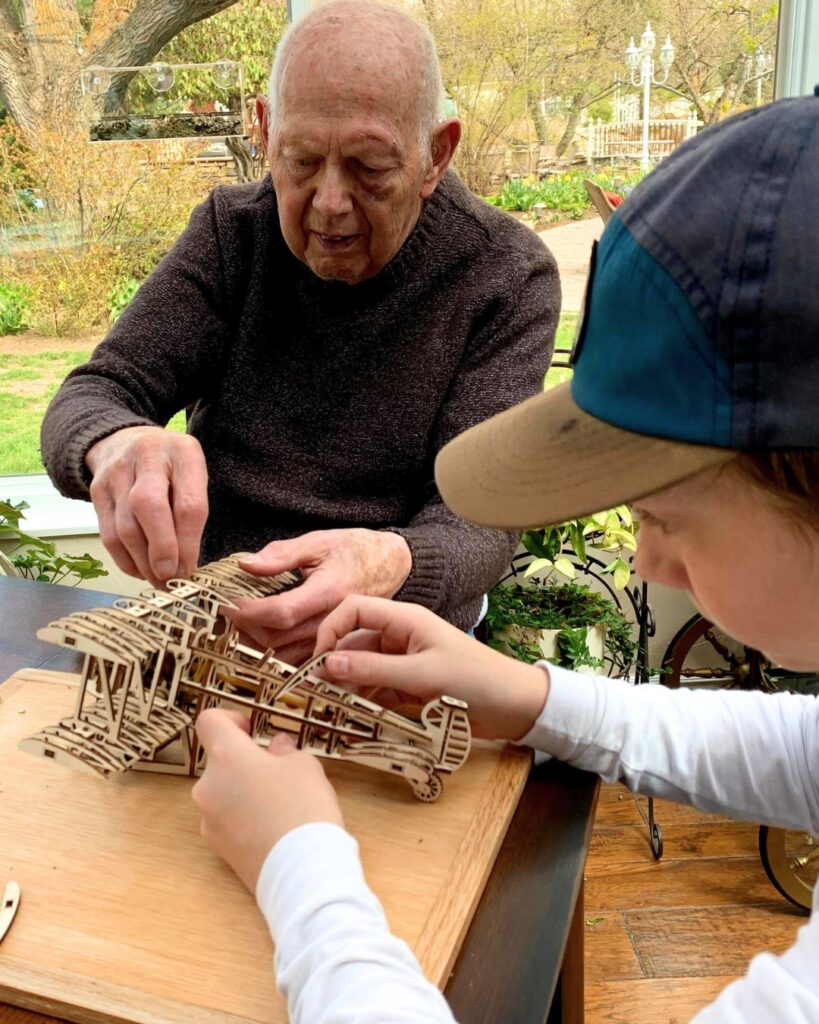 man and a boy with a wooden airplane model