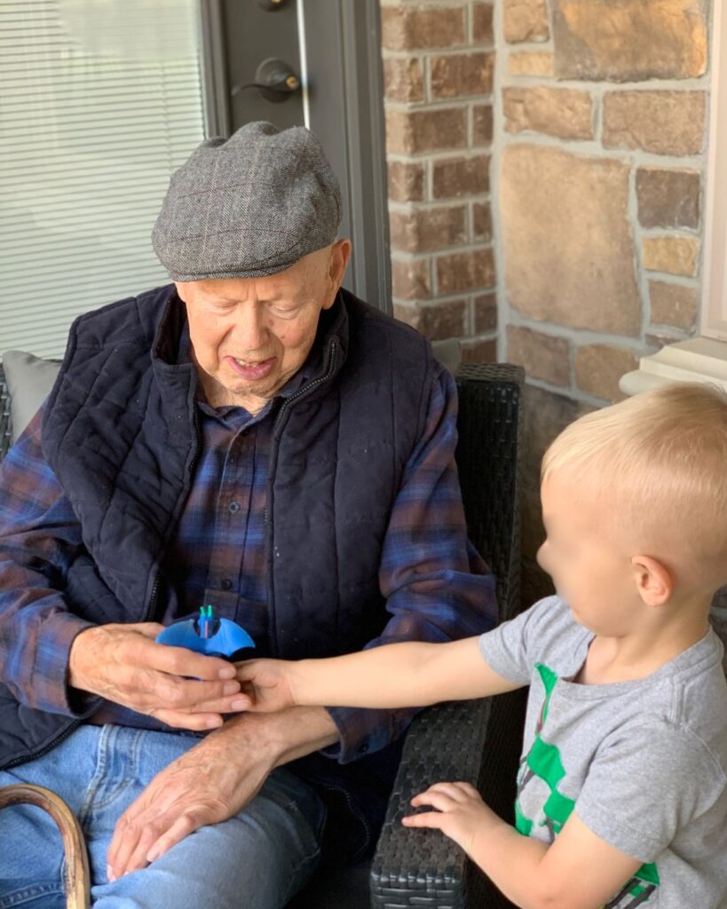 Small boy handing a toy to an older man