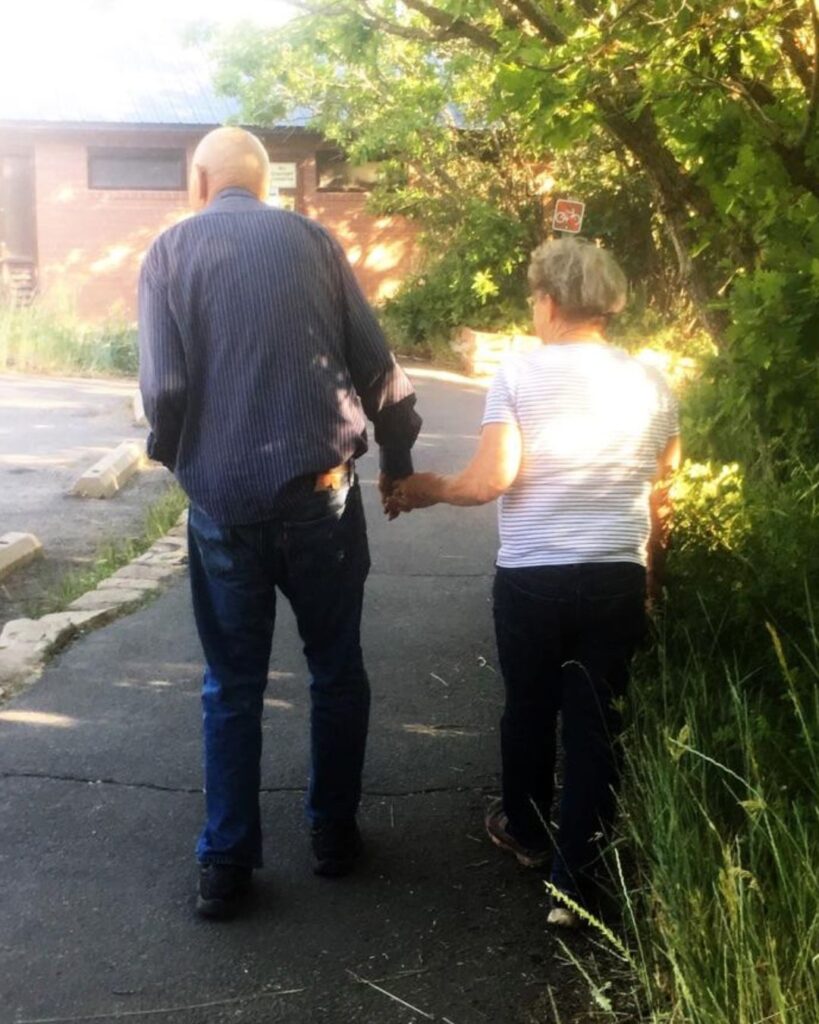 man walking with wofe hand in hand