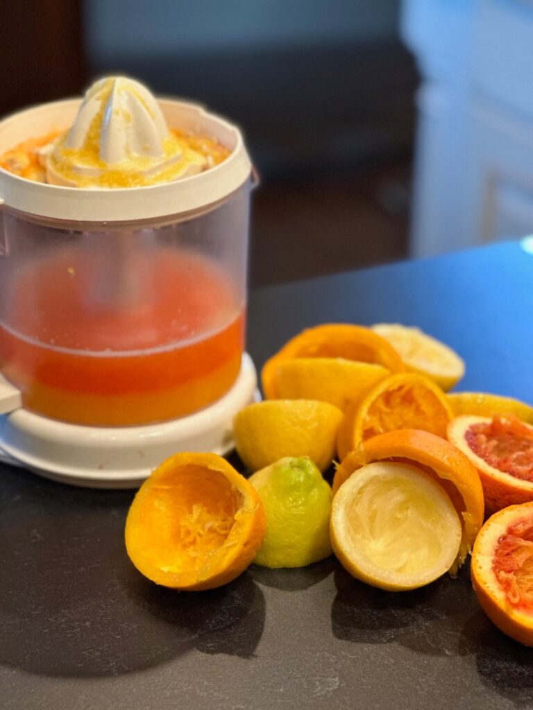 juicer full of juice plus empty citrus skins