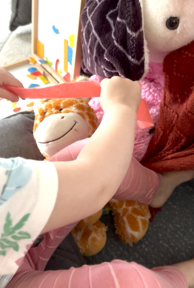 child bandaging a stuffed animal