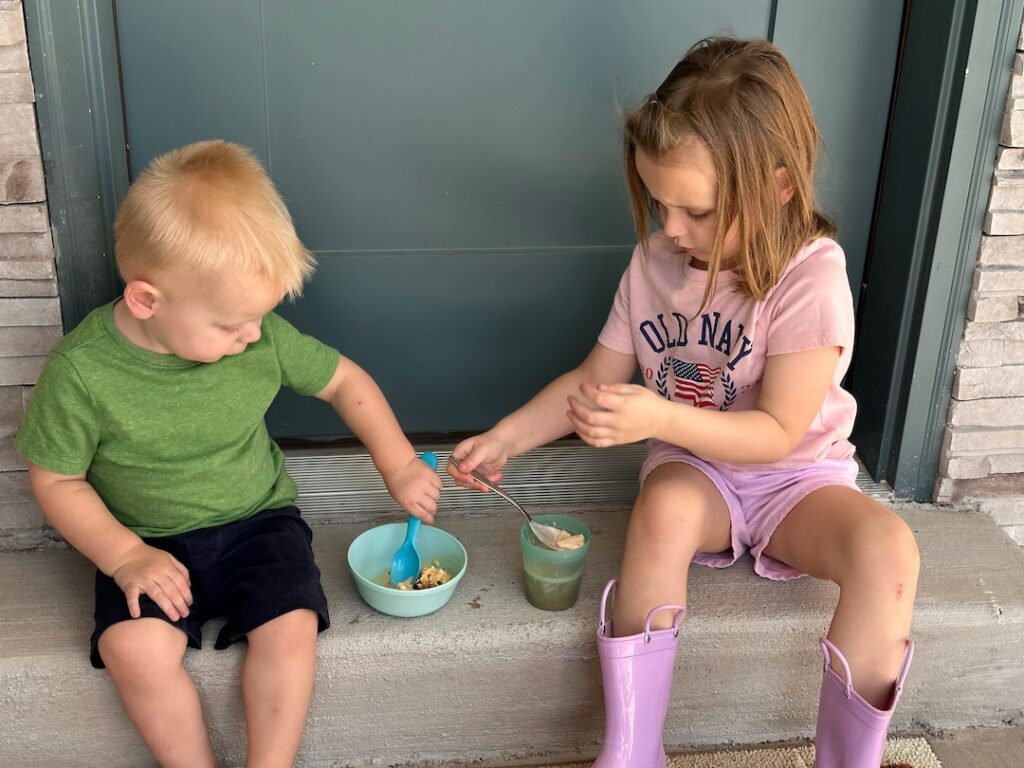 two children eating ice cream on the porch