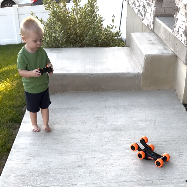 toddler playing with remote-controlled car